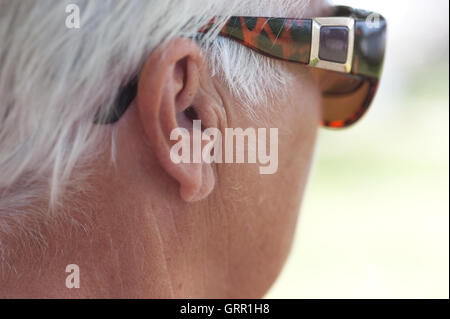 I capelli bianchi e i bicchieri sopra l'orecchio Foto Stock