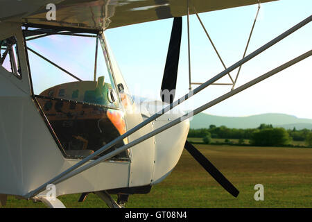 Velivolo ultraleggero in sunset al aeroporto di erba con la riflessione Foto Stock