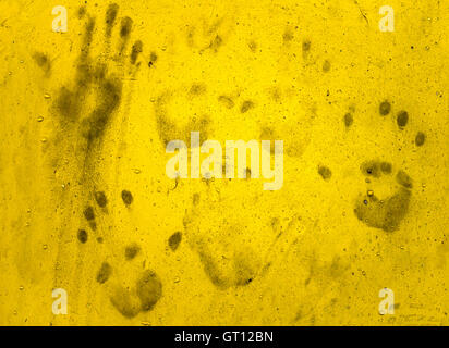 Mano sporca stampe su muro giallo. Idee per Halloween di sfondo Foto Stock