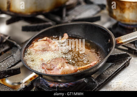 Gambe di anatra friggere in una padella Foto Stock
