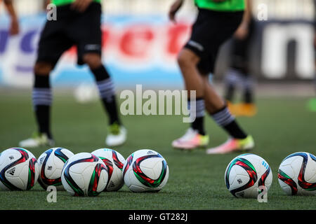 Salonicco, Grecia - 24 Giugno 2016: pallone da calcio in primo piano e le gambe i giocatori in backraount nella formazione del team Paok Foto Stock