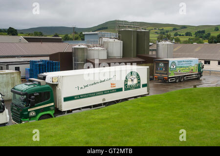 In caso di pioggia, 2 autocarri con loghi, parcheggiato al di fuori della fabbrica di formaggio - Wensleydale Creamery, Hawes, Yorkshire Dales, Inghilterra. Foto Stock