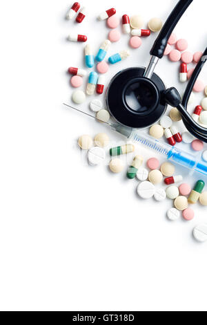 Le diverse pillole , uno stetoscopio e la siringa isolati su sfondo bianco. Vista dall'alto. Foto Stock