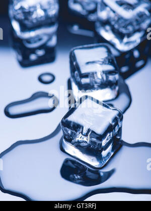 Pezzi fusi di ghiaccio su uno sfondo scuro Foto Stock