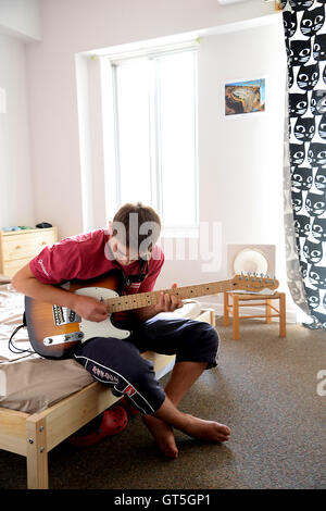 19 anni di sesso maschile gioca la sua Fender Telecaster chitarra in residenza per studenti. Foto Stock