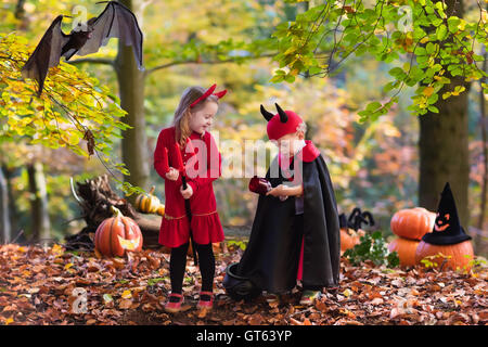 Due bambini divertenti indossando devil e vampire costume rosso con corna e trident trucco o trattamento di Halloween. Foto Stock