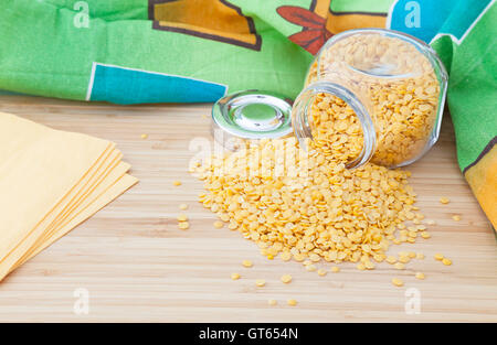 Giallo lenticchia turca in un vasetto di vetro con tovaglioli su una tavola di legno Foto Stock