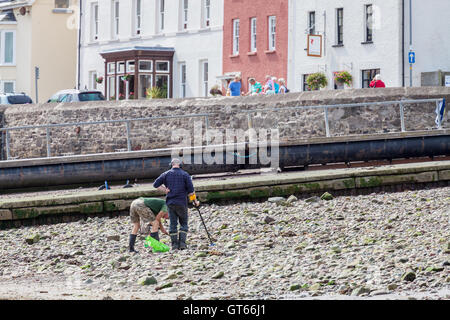 Due uomini usando un rivelatore di metalli a Dale beach, Pembrokeshire Foto Stock