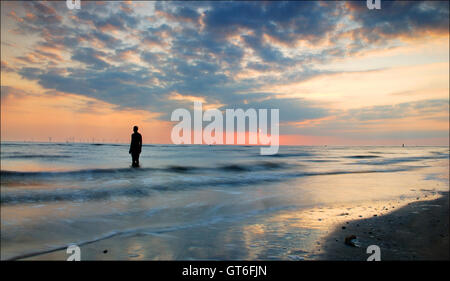 Anthony Gormley è un altro luogo gli uomini di ferro statue, Crosby beach, Liverpool, Merseyside, Regno Unito Foto Stock