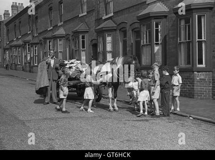 Rag e uomo di osso di cavallo e carrello circondato da bambini in street Birmingham West Midlands Uk degli anni cinquanta la Gran Bretagna Foto Stock