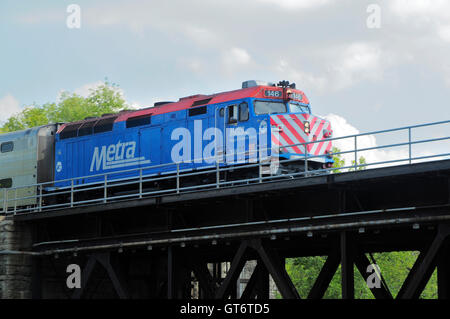 Il treno dei pendolari in croce il fiume sul ponte Foto Stock