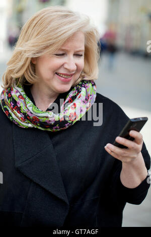 Coppia bella donna legge il messaggio sul telefono sulla molla street Foto Stock