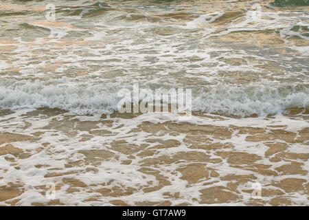 Il mare poco profondo e piccole onde con la schiuma sulla sua sommità Foto Stock