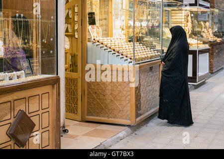 Donna iraniana in chador guardando oro in un negozio gioielli in vetro Yazd, Iran. Foto Stock