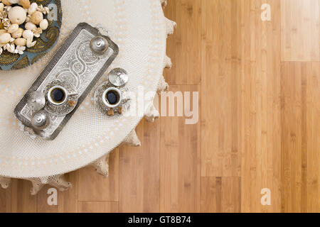 Angolo di Alta Vista di caffè turco per due posti sul tavolo bianco su un pavimento di legno, sottolineando i testi di spazio. Foto Stock
