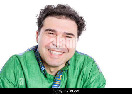 Felice uomo bello con ricci capelli castani indossando un verde afro-shirt guardando la telecamera con un ampio sorriso raggiante di piacere Foto Stock