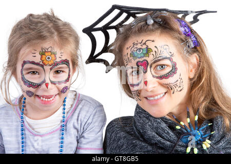 Pretty Woman e il suo grazioso giovane figlia in Halloween trucco indossando un ragno e la sua web guardando la telecamera con felice playf Foto Stock