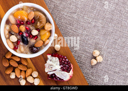 Noè del cibo o ashure, una specialità dolce turco budino di grano, servito con le nocciole, le mandorle e i semi di melograno, overhead Foto Stock