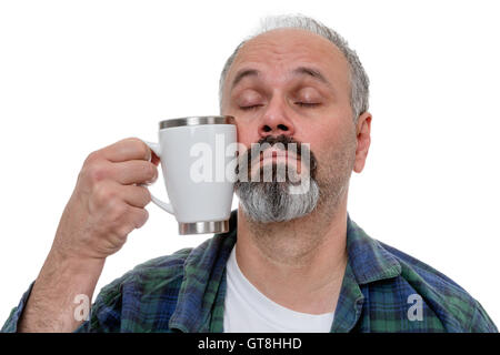 Assonnato uomo di mezza età con linea sottile sfuggente e barba lottando per portare una tazza di caffè in bocca dopo il risveglio Foto Stock