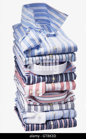 Pila di multi colorata, camicie a righe su sfondo bianco, studio shot Foto Stock
