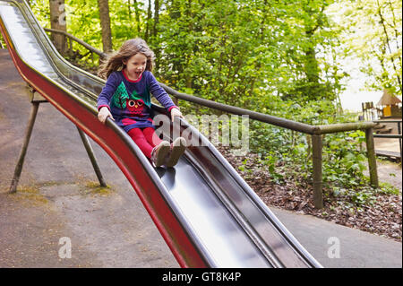 5 anno vecchia ragazza divertirsi su una slitta a un parco giochi, Germania Foto Stock