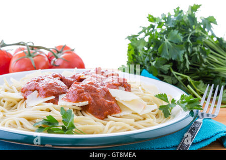 Preparati piatto di spaghetti pasta farcita con formaggio grana padano, prezzemolo e salsa rossa circondata da pomodori e f Foto Stock