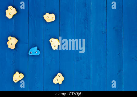 Vista dall'alto in basso su sette stranamente sagomate giallo e blu di arrampicata di maniglie di presa sulla parete in legno con spazio di copia Foto Stock