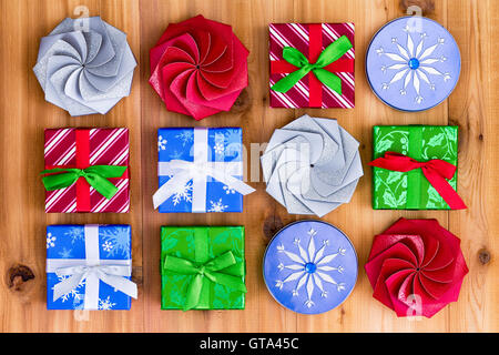 Vista dall'alto in basso su dodici piccolo grazioso regalo di Natale in scatole blu, rosso e verde e con diversi tipi di nastri e fiocchi di lu Foto Stock
