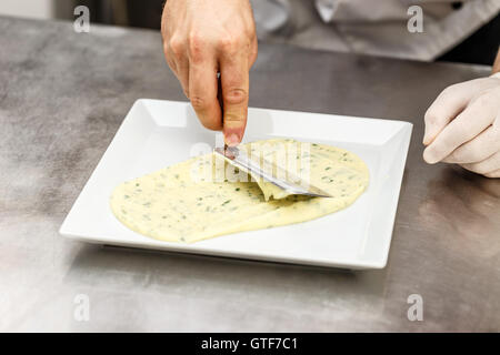 Lo Chef guarnendo il suo piatto, iniziare con purè di patate Foto Stock