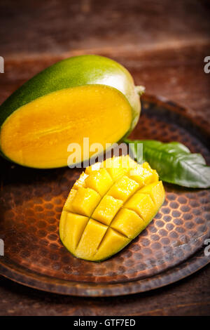 Fetta di mango tagliati a cubetti su sfondo rustico Foto Stock