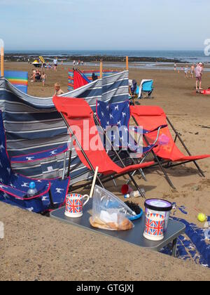 Foraged alghe, Union Jack tazze e Marks & Spencer tratta. Una famiglia della classe media imposta camp su Scarborough North Bay beach Foto Stock