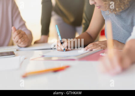 Imprenditrice prendendo appunti in riunione Foto Stock