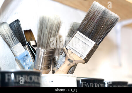 (Mobili) pittura e restauro pennelli e barattoli di vernice. di arti e mestieri e il lavoro. Foto Stock