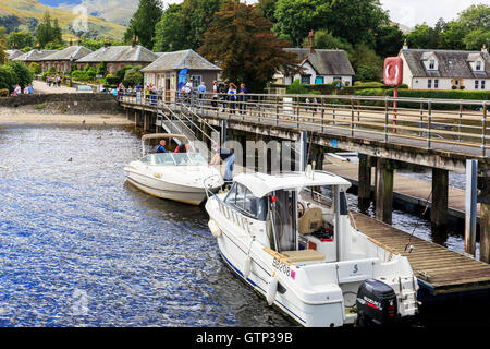 Dal Molo presso Luss, Loch Lomond, con due barche a motore e turisti, Scotland, Regno Unito Foto Stock