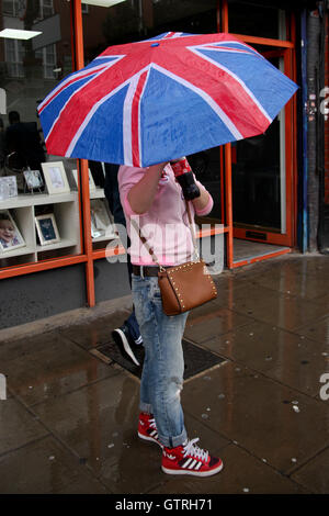 Londra, Regno Unito. Decimo Sep, 2016. Weekend shoppers riparo dalla pioggia nel nord di Londra durante il pesante docce a pioggia e un clima umido. Credito: Dinendra Haria/Alamy Live News Foto Stock