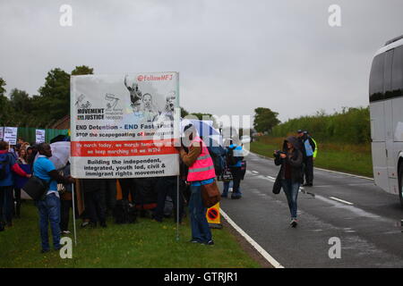Milton Ernest, Bedford, Regno Unito. 10 settembre 2016. Gli attivisti del movimento per la giustizia tengono una protesta su strada sotto la pioggia, mostrando striscioni e cartelli che chiedono la fine della detenzione degli immigrati e delle politiche di espulsione rapida. I partecipanti includono fotografi e dimostranti in gilet rosa. Centinaia di manifestanti protestano contro il recinto del centro di detenzione Yarls Wood chiedendo la chiusura della struttura. Penelope Barritt/Alamy Live News Foto Stock