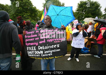 Milton Ernest, Bedford, Regno Unito. 10 settembre 2016. I manifestanti si riuniscono in condizioni piovose per protestare contro la detenzione dell'immigrazione nel Regno Unito. Un cartello centrale cita Malcolm X e chiede il rilascio dei detenuti e la chiusura dei centri di detenzione. L'evento è organizzato dal movimento per la giustizia. Centinaia di manifestanti protestano contro il recinto del centro di detenzione Yarls Wood chiedendo la chiusura della struttura. Penelope Barritt/Alamy Live News Foto Stock