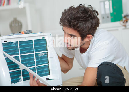 Uomo che fissa unità aria condizionata Foto Stock