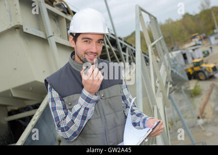 L'uomo sul sito di costruzione utilizzando walkie-talkie Foto Stock