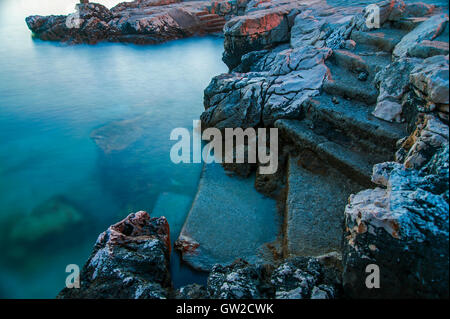 Tramonto su Novi Vinodolski beach, Croazia. Esposizione lunga Foto Stock