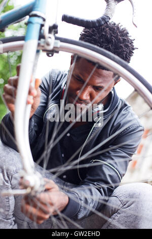 Giovane uomo nel controllo della sua ruota di bicicletta Foto Stock