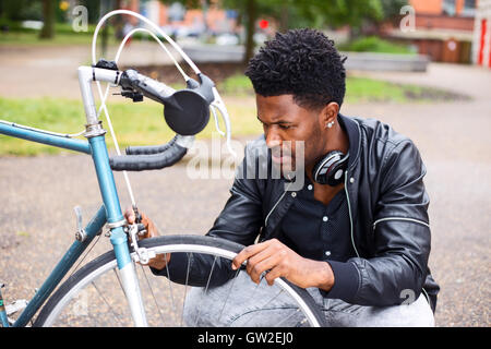 Giovane uomo nel controllo della sua ruota di bicicletta Foto Stock