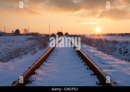 Tramonto in inverno sulla ferrovia abbandonata vie Foto Stock