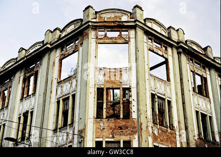 Tracce di proiettili su una facciata di edificio distrutto dalla guerra Foto Stock