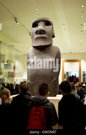 I turisti la visualizzazione di un moai (l'Isola di Pasqua) statua, British Museum di Londra, Regno Unito. Foto Stock