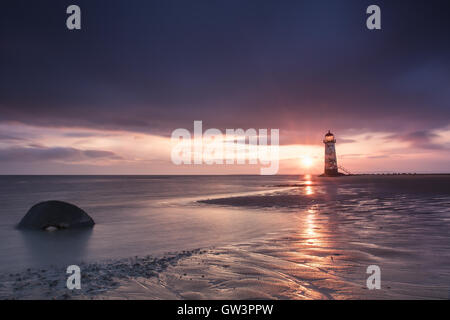 Vista del Talacre Lighthouse in Galles a sunrise vicino al mare. Blu cielo e riflessioni sulla sabbia Foto Stock