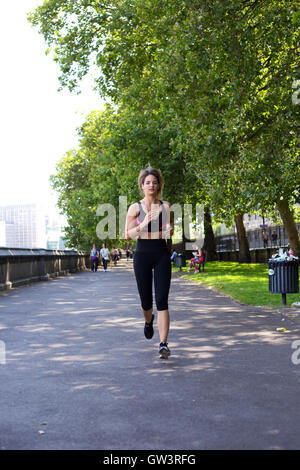 Giovane donna che corre lungo il fiume Foto Stock