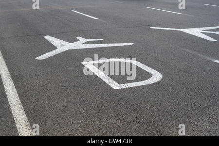 Aeroporto segnaletica direzionale sulla strada. Colore bianco segno di aereo e la lettera 'D' dirige all'aeroporto terminale D. Foto Stock