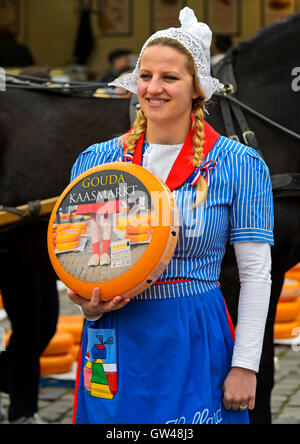 Formaggio olandese la ragazza con il formaggio Gouda truckle, mercato del formaggio Gouda, Paesi Bassi Foto Stock