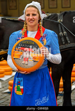 Formaggio olandese la ragazza con il formaggio Gouda truckle, mercato del formaggio Gouda, Paesi Bassi Foto Stock